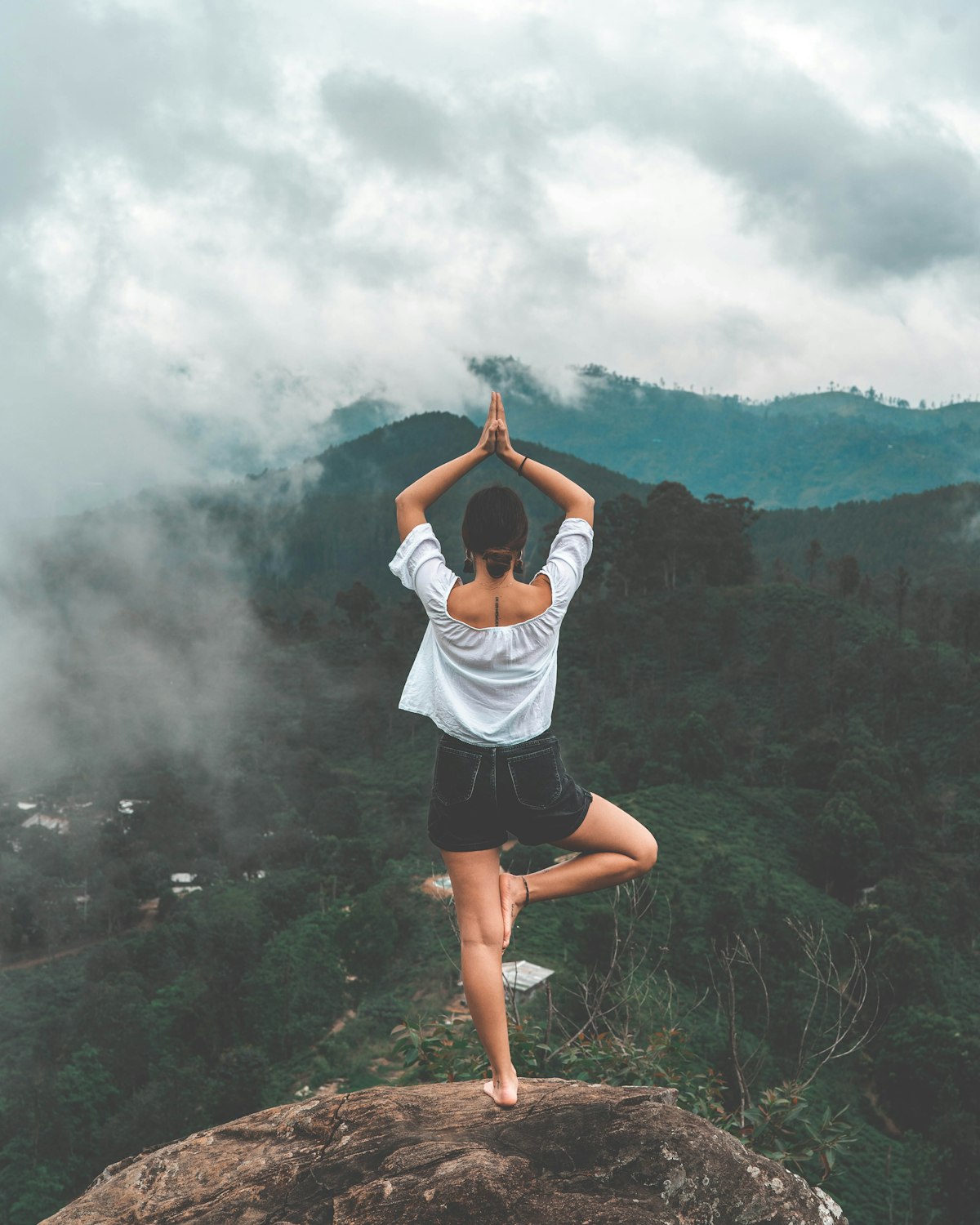 A person standing calmly in a quiet, misty mountain landscape